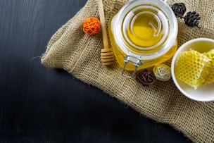 a jar of honey on burlap with honey utensil