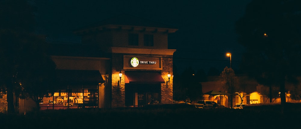 a starbucks coffee shop lit up at night