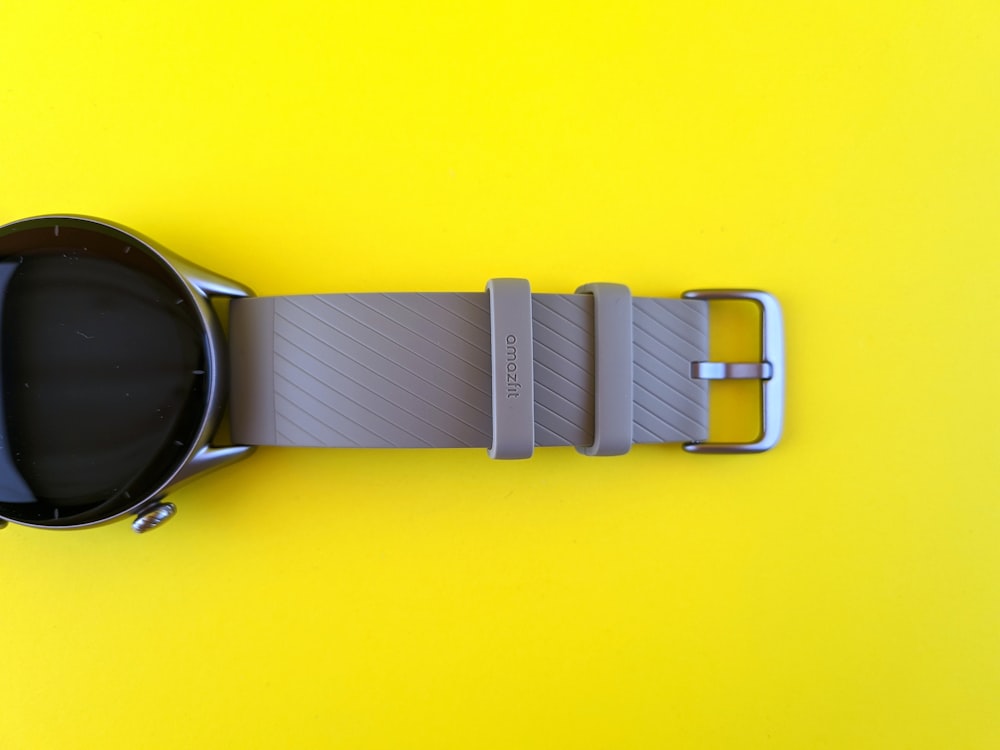 a smart watch sitting on a yellow surface