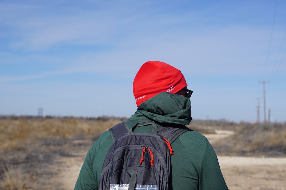 eine Person mit einem Rucksack auf einem Feldweg