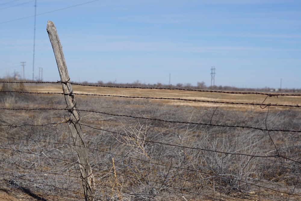 a barbed wire fence in the middle of a field