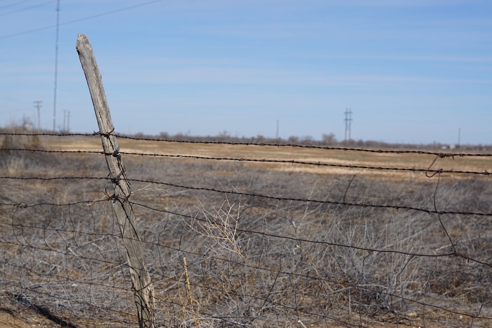 una cerca de alambre de púas en medio de un campo