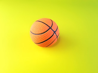 an orange and black basketball on a yellow and green background