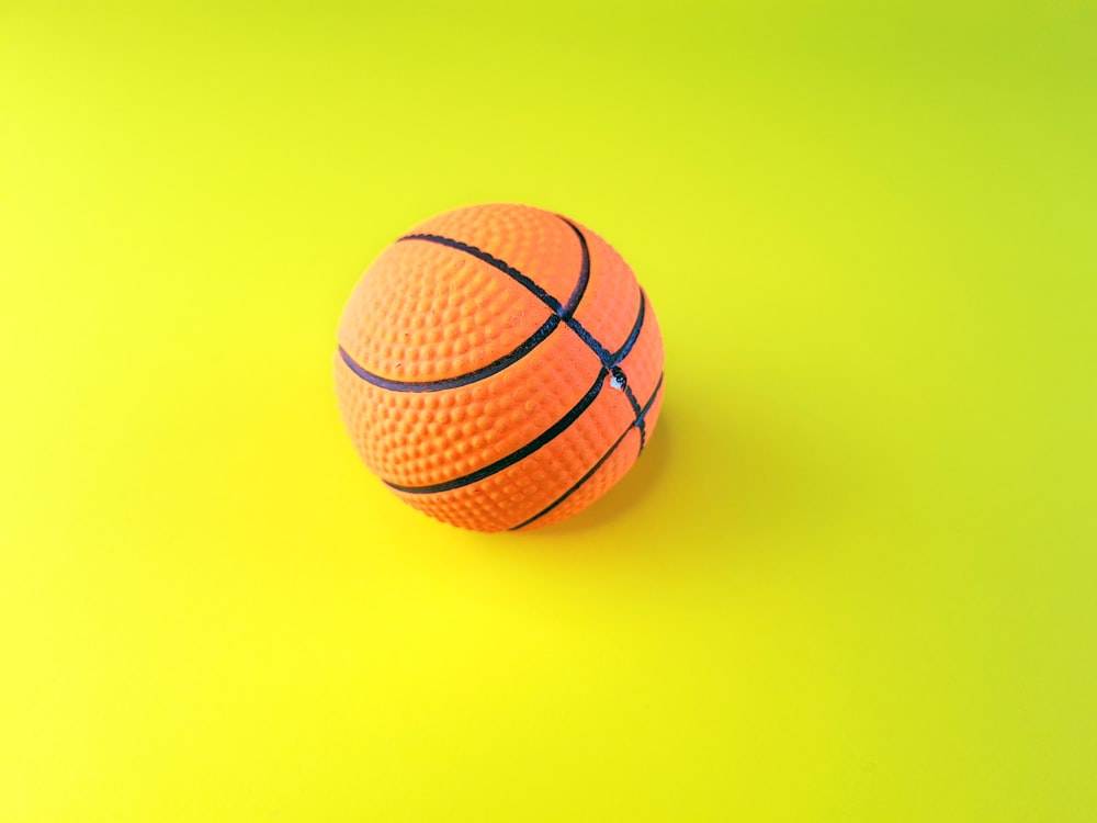 an orange and black basketball on a yellow and green background