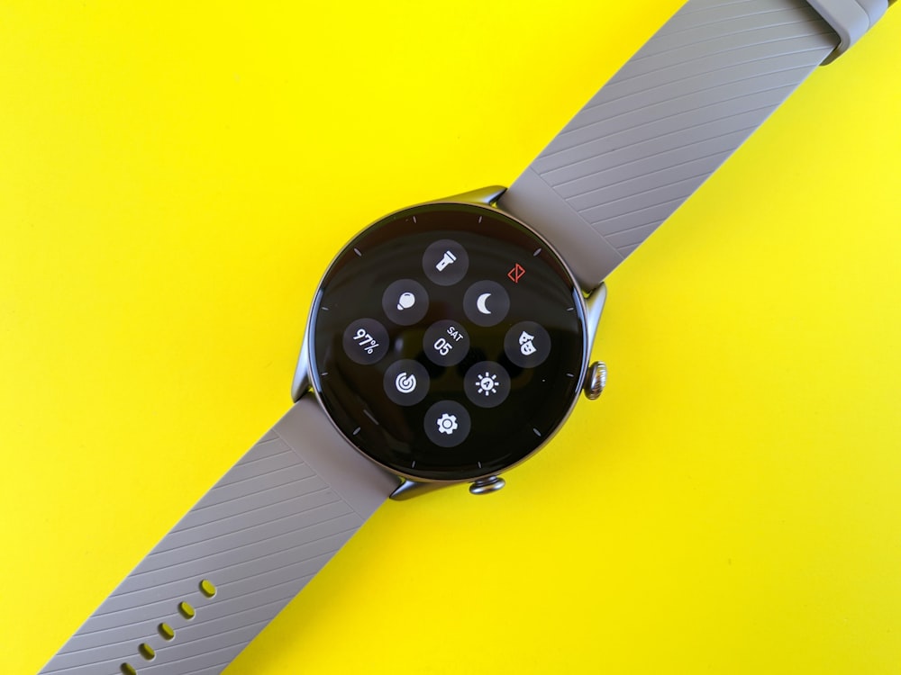 a smart watch sitting on top of a yellow surface