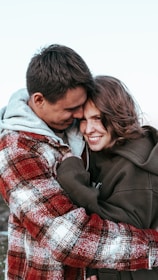 A family happily reunited at an airport arrival gate, embracing warmly.