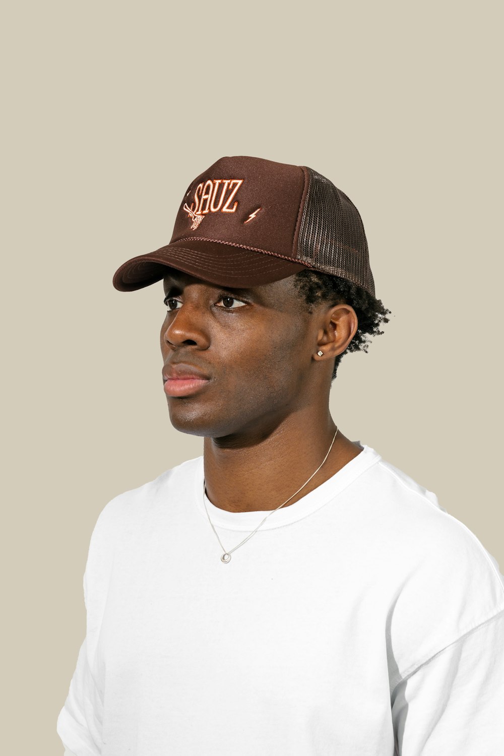 a man wearing a brown hat and white shirt