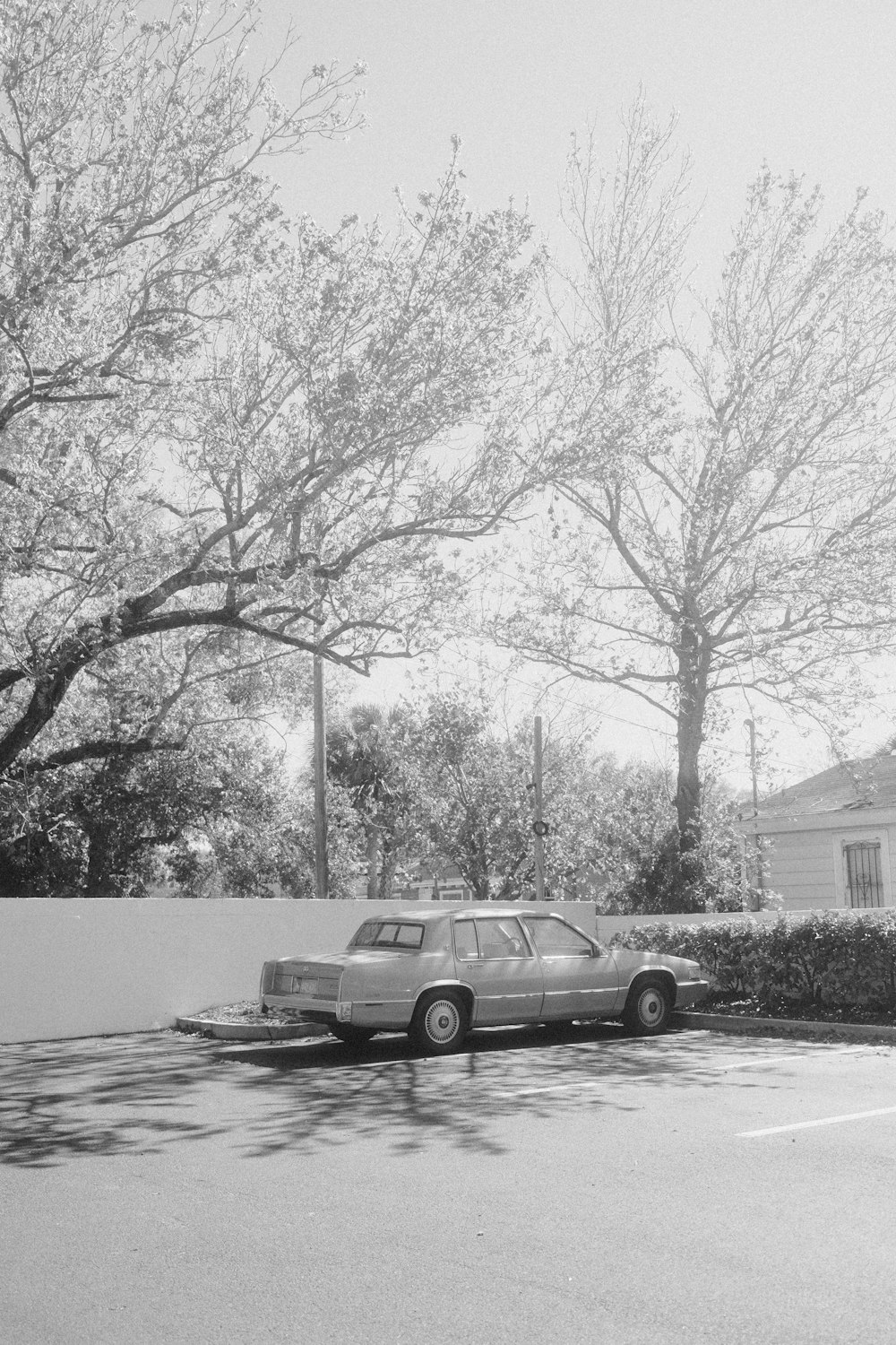 a black and white photo of a car parked in a parking lot