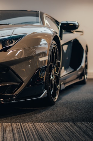 A sleek sports car being detailed with precision under bright studio lights, highlighting the shine of premium car care products.