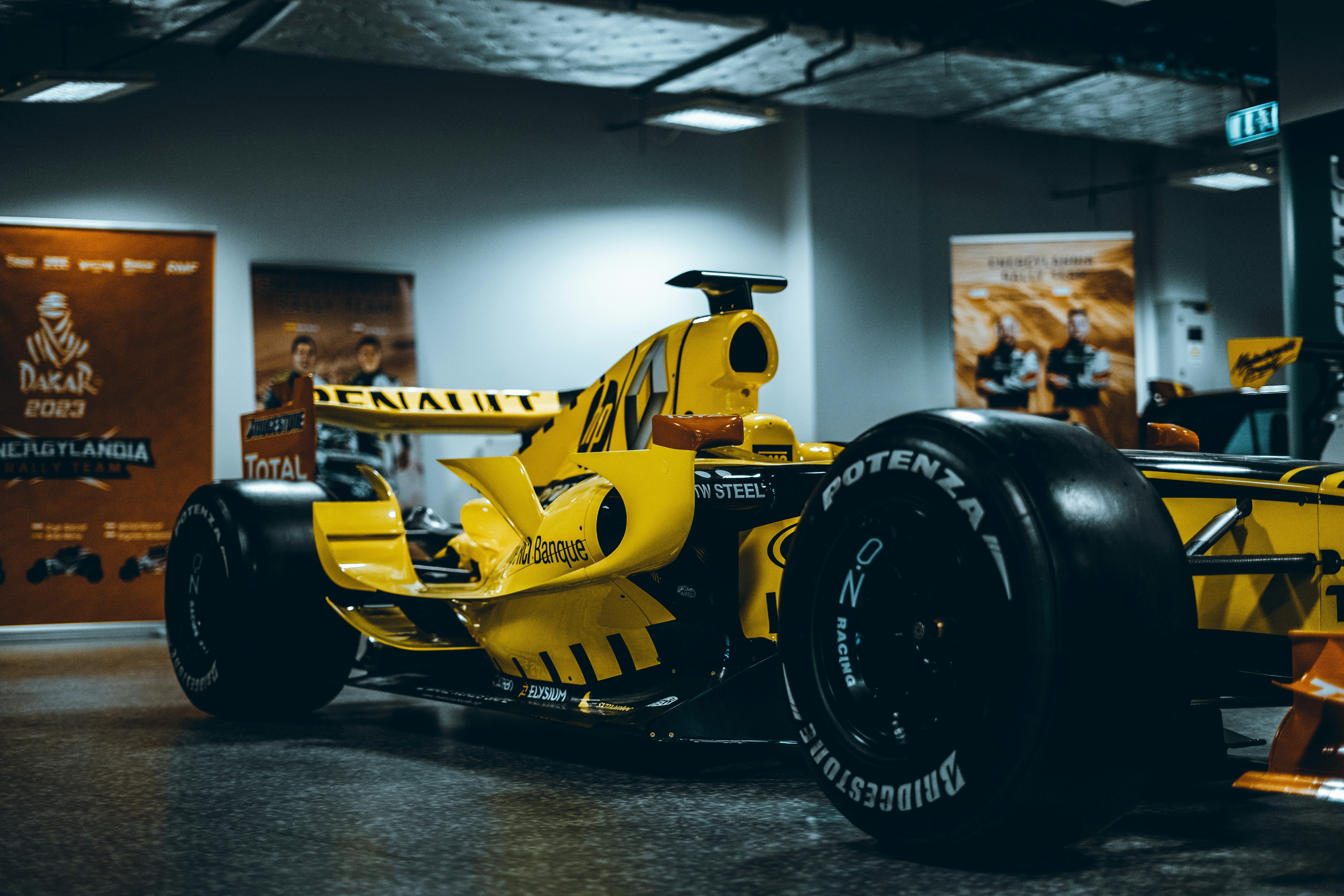 a yellow race car is on display in a museum