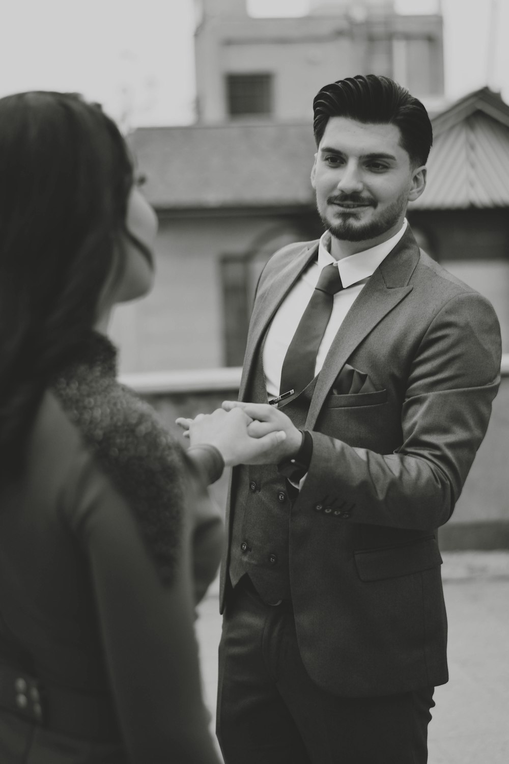 a man in a suit and tie standing next to a woman