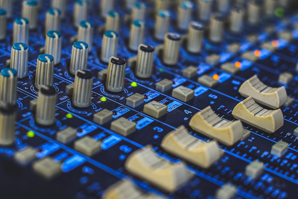 a close up of a sound board with many knobs