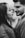 A couple facing each other closely, suggesting intimacy and affection. The woman has long hair and is wearing a textured garment, while the man has a neatly trimmed beard and is dressed in a suit. The image is in black and white, emphasizing contrast and depth.