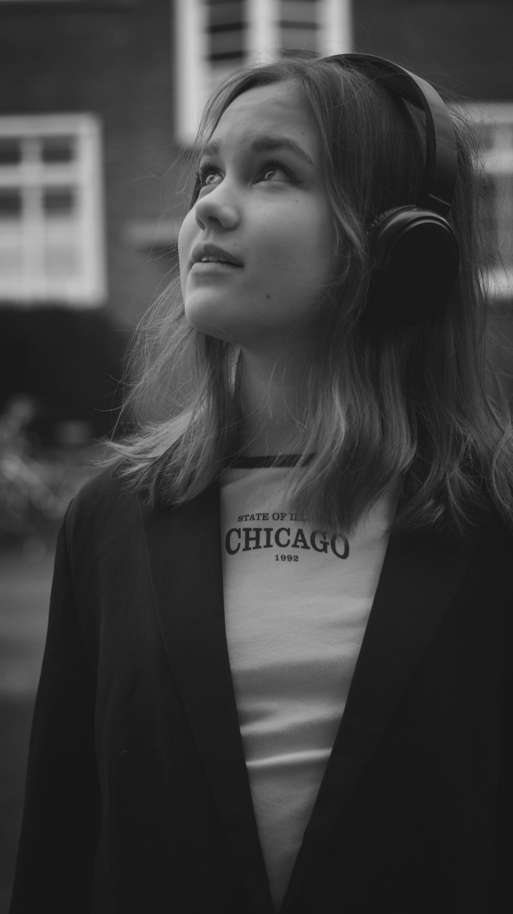 a woman wearing headphones standing in front of a building