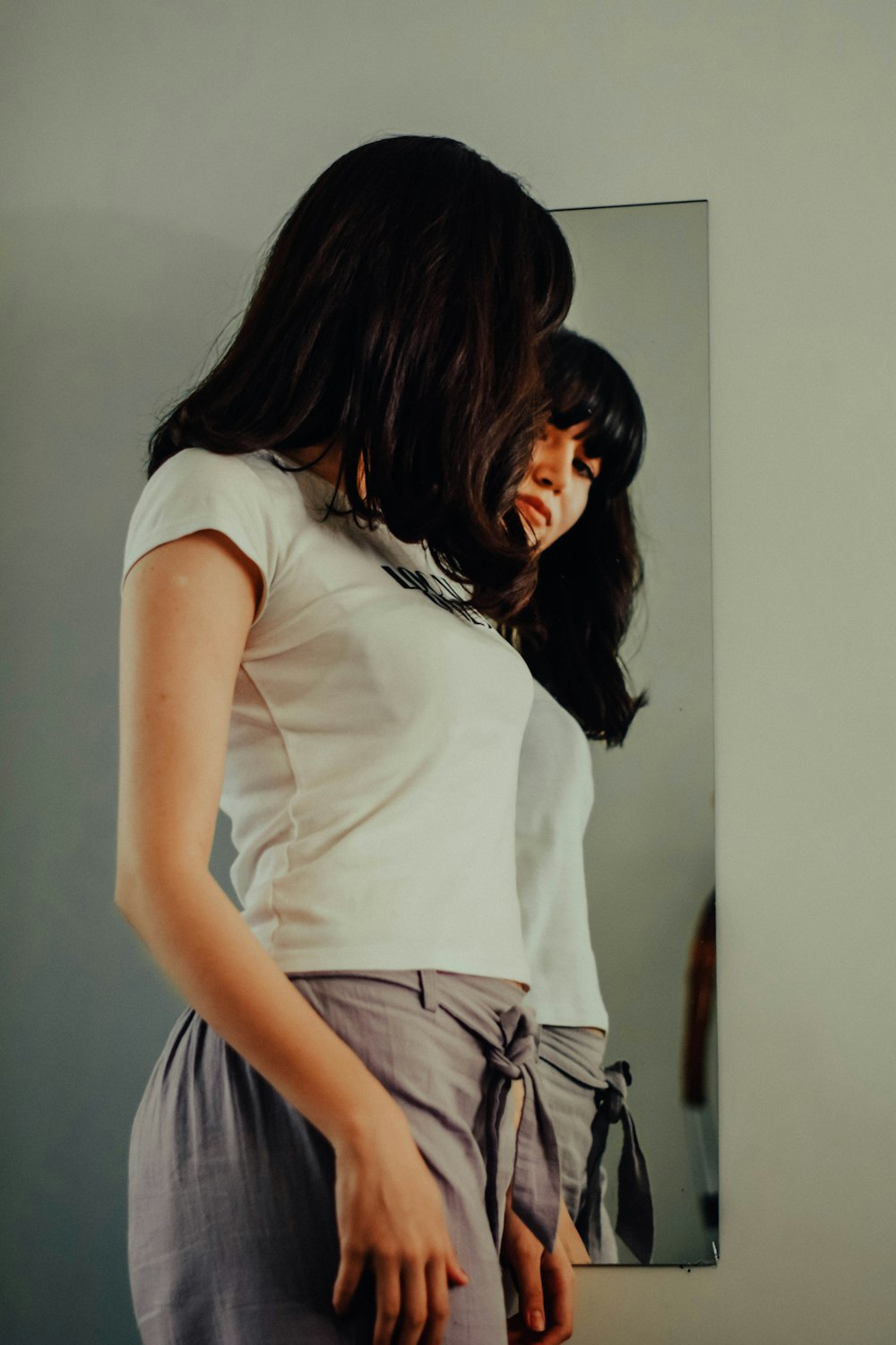 a woman standing in front of a mirror