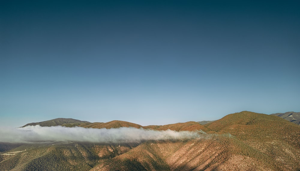 une vue d’une chaîne de montagnes avec un nuage dans le ciel