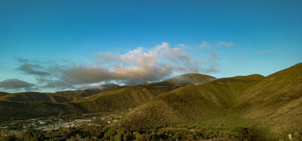 a scenic view of a valley with mountains in the background