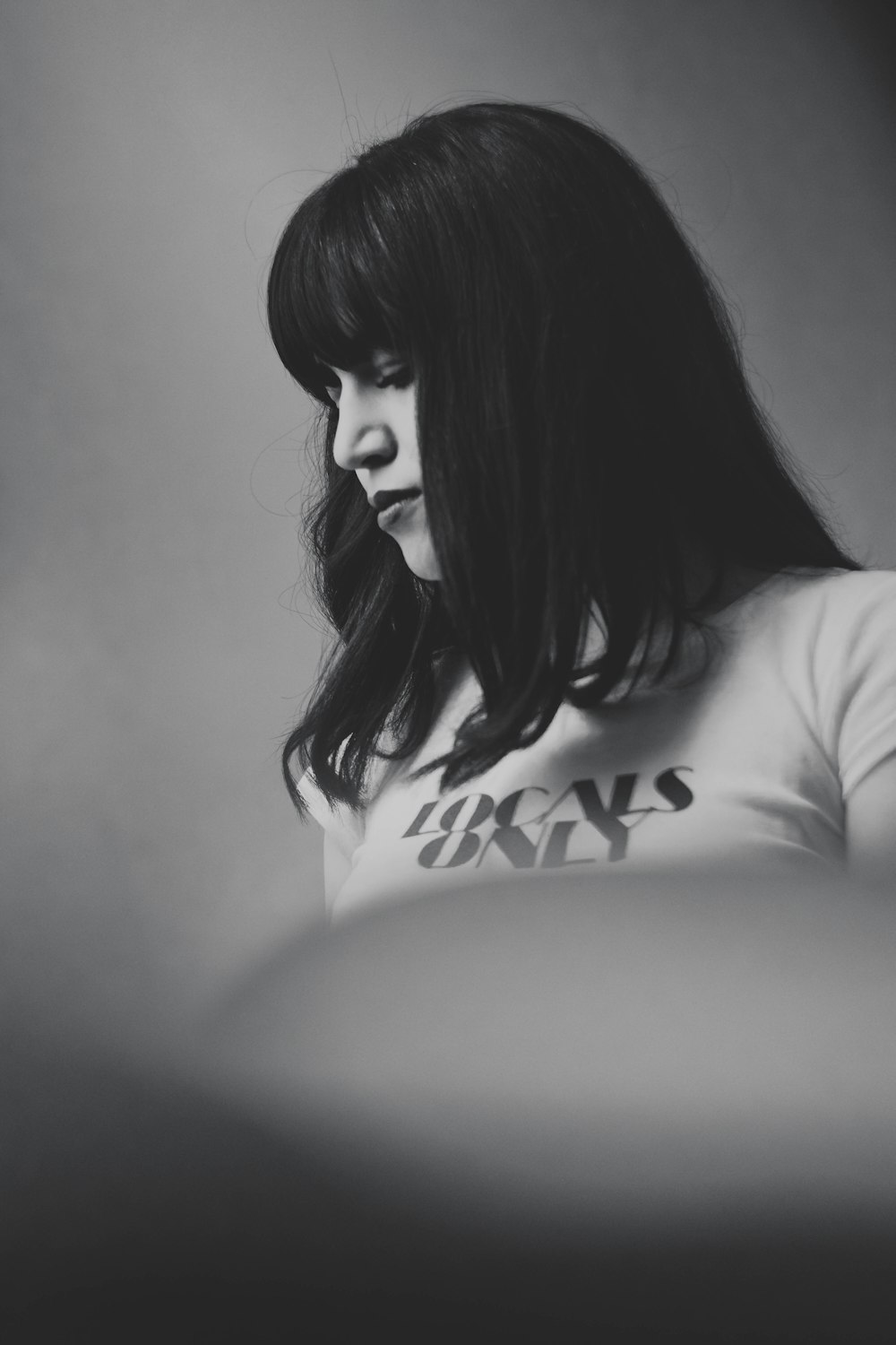 a black and white photo of a woman looking down