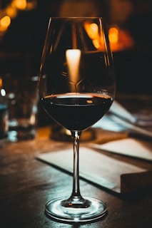 a glass of wine sitting on top of a table