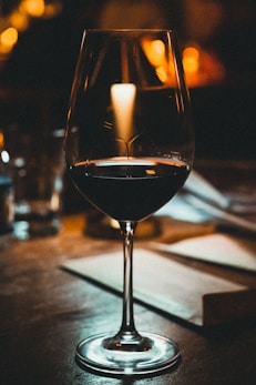 a glass of wine sitting on top of a table