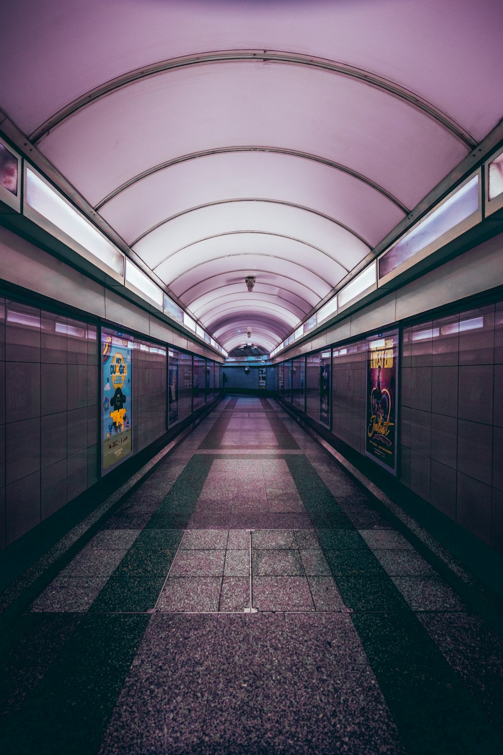 a long hallway with a purple ceiling and tiled floor