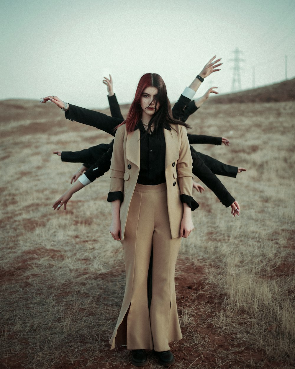 a woman standing in a field with her arms outstretched