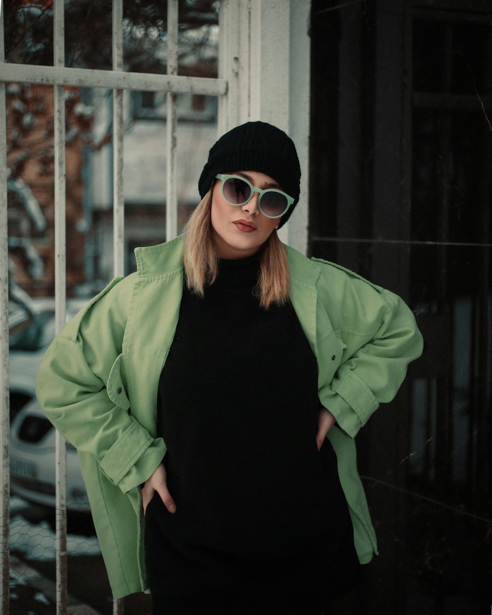 a woman in a black dress and a green jacket