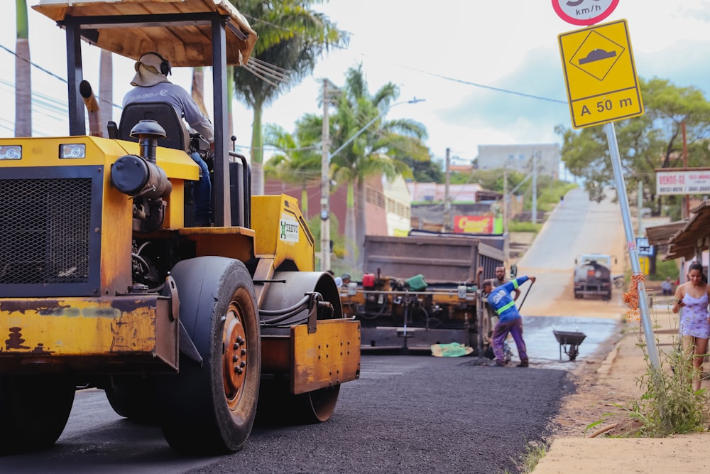 a man driving a construction vehicle down a street