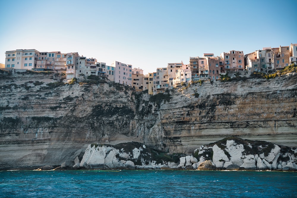 a city on the side of a cliff next to a body of water