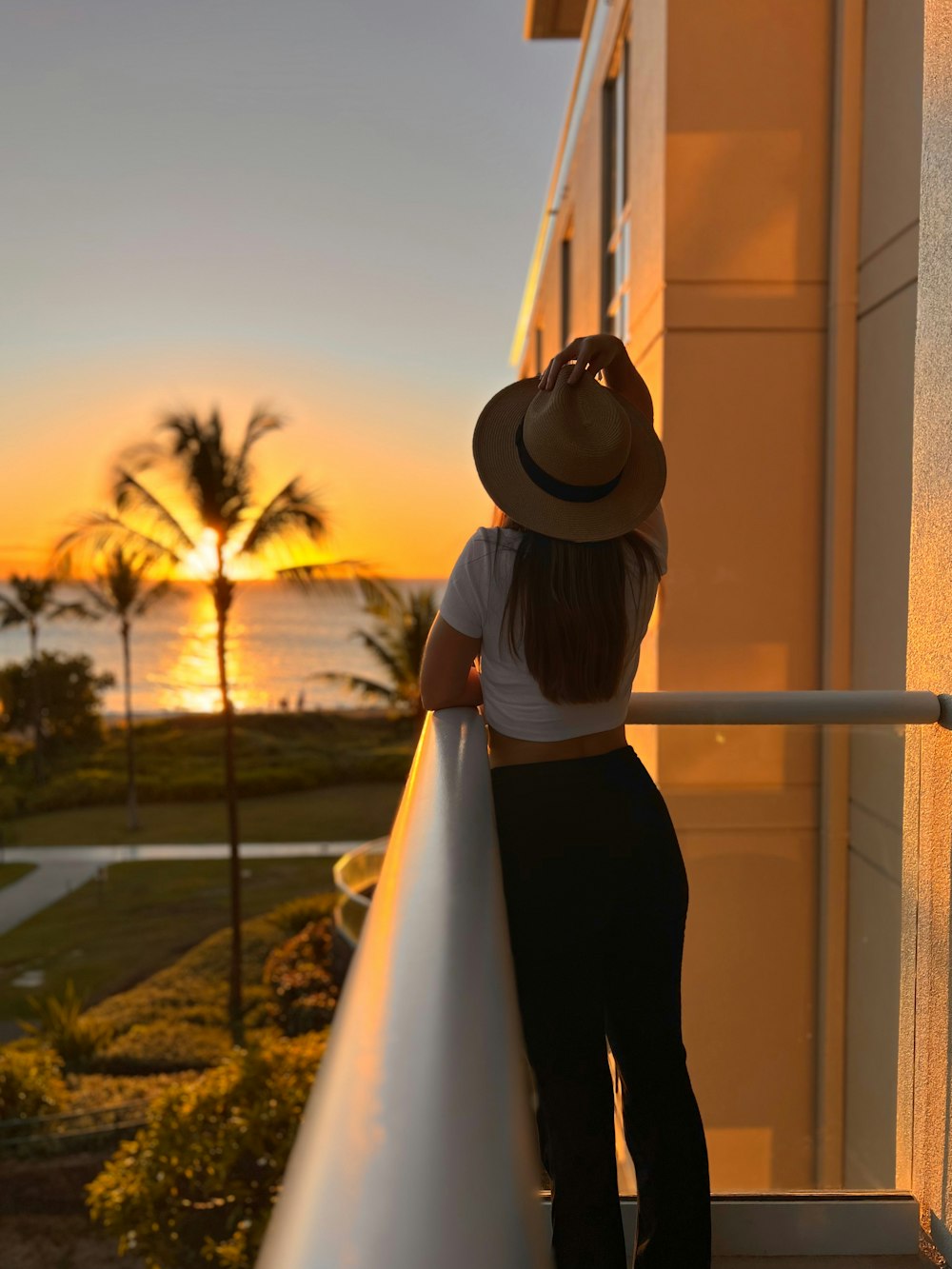 a woman standing on a balcony next to a building