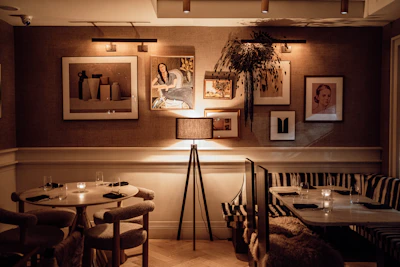 A cozy corner of the restaurant with warm lighting and elegant table settings reflecting the impressionist art theme.