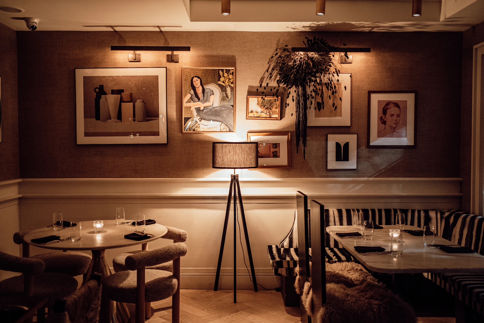 A dimly lit dining area featuring minimalist black decor and soft ambient lighting, creating an intimate atmosphere.