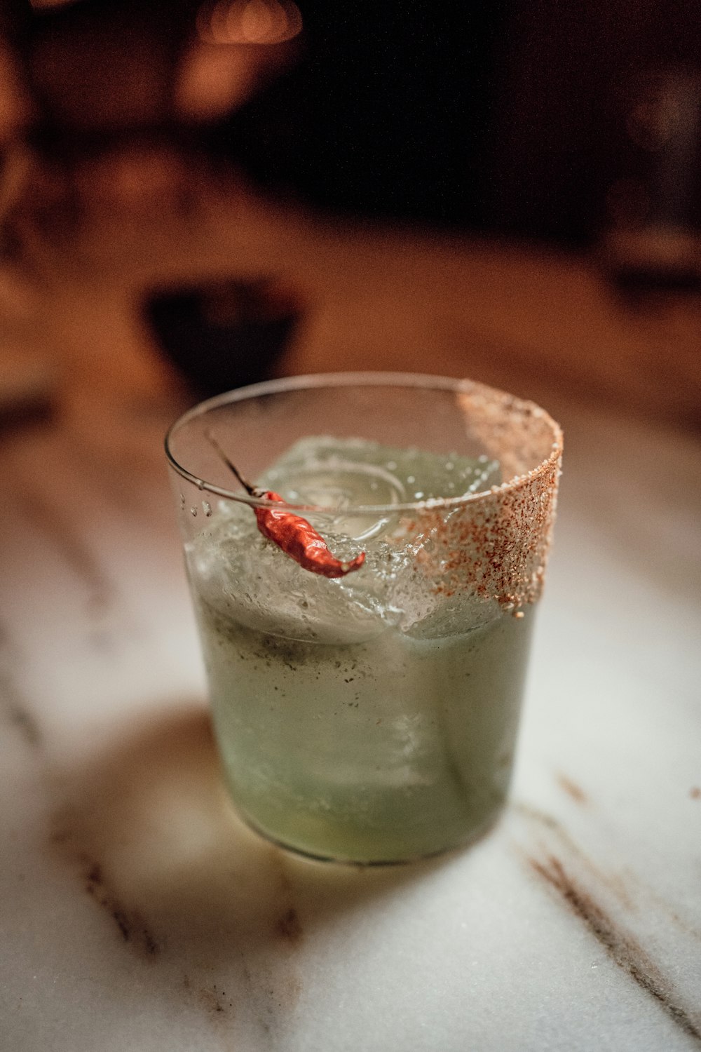 a small glass filled with a drink on top of a table