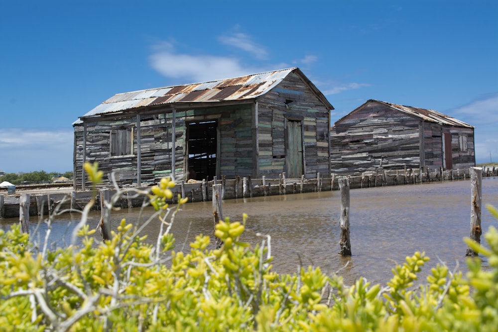 an old wooden shack sitting on top of a body of water