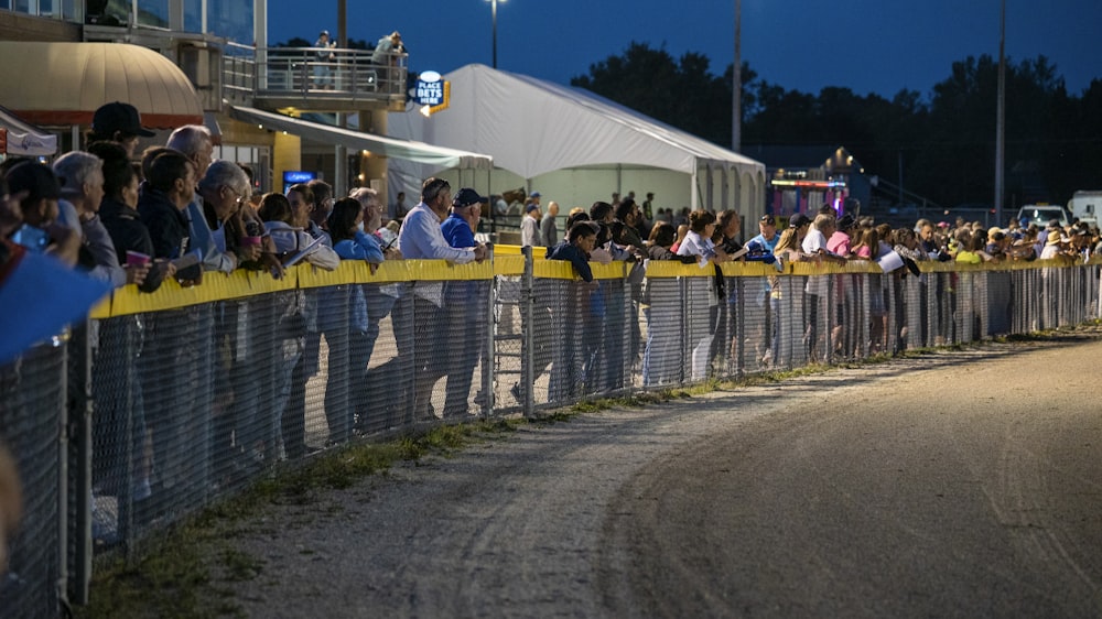 a crowd of people watching a race at night