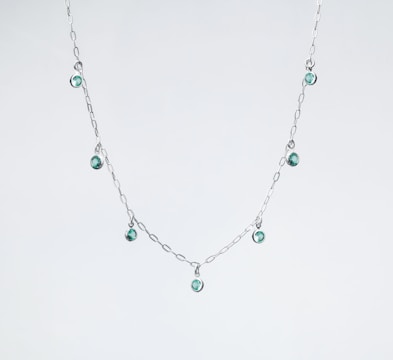A beautiful silver necklace with gemstones.