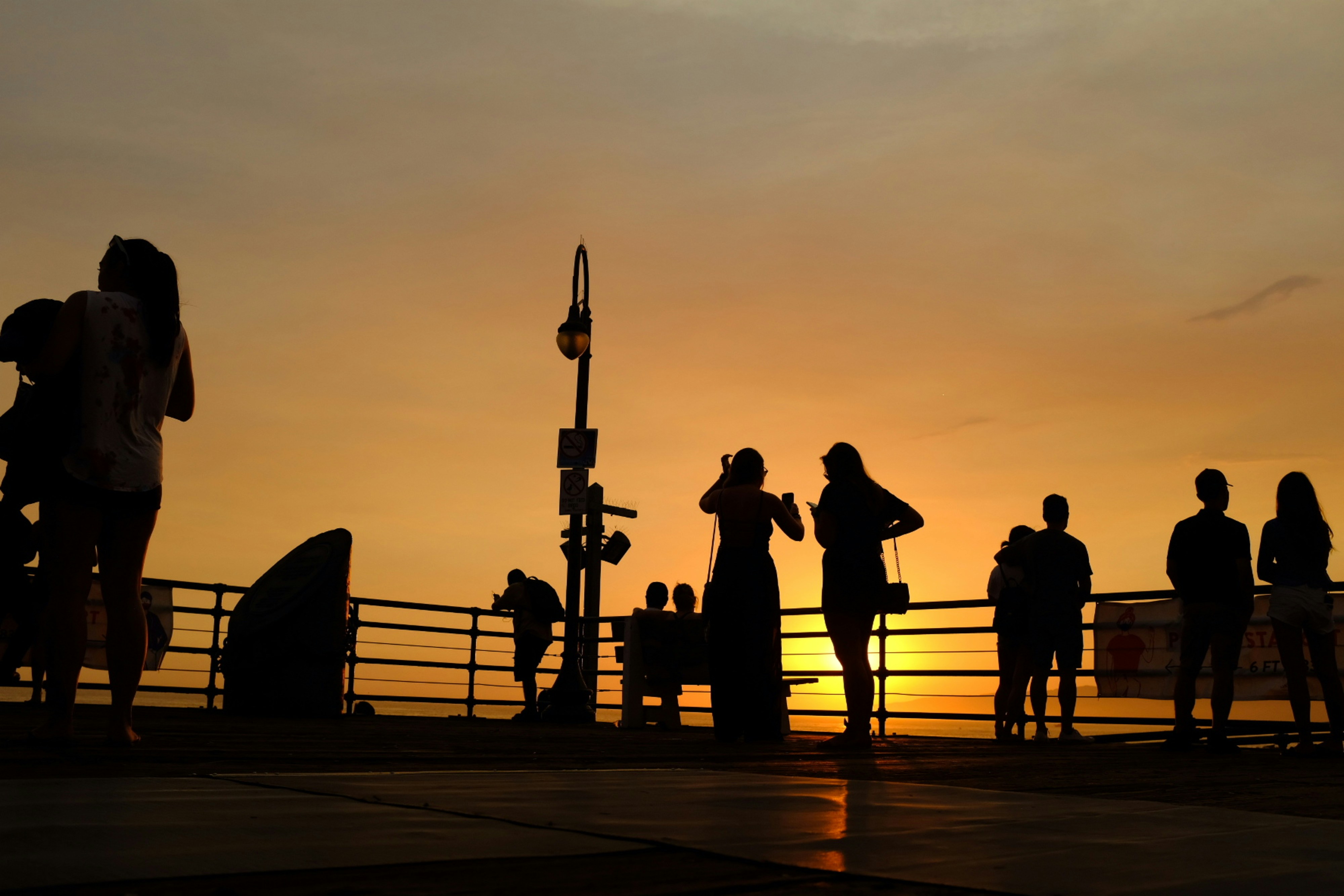 a group of people standing on top of a pier