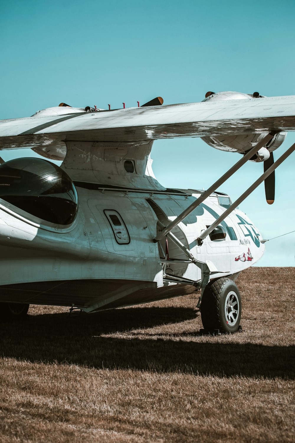 a small airplane parked on top of a dry grass field