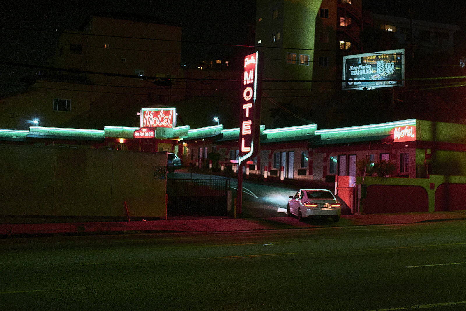 a car parked in front of a motel at night