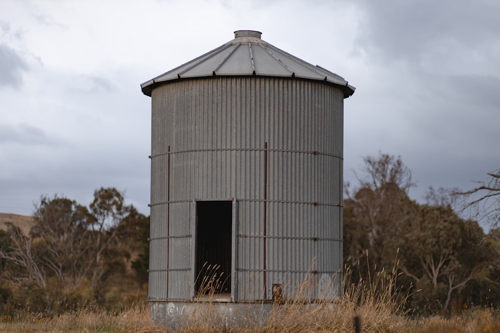 a large metal silo sitting in the middle of a field