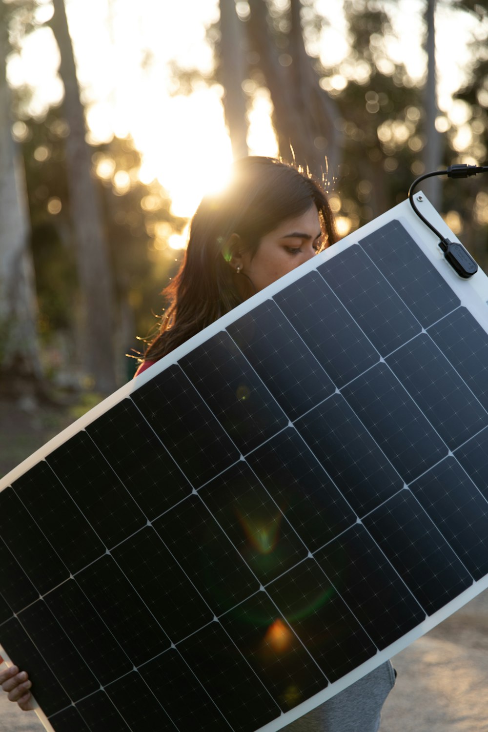 a woman holding a solar panel in front of her face