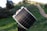 A happy customer holding a solar panel in front of their home.