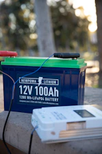 a blue and green battery sitting on top of a cement wall