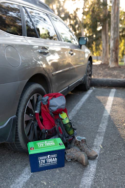 a car parked in a parking lot next to a box with a backpack on it