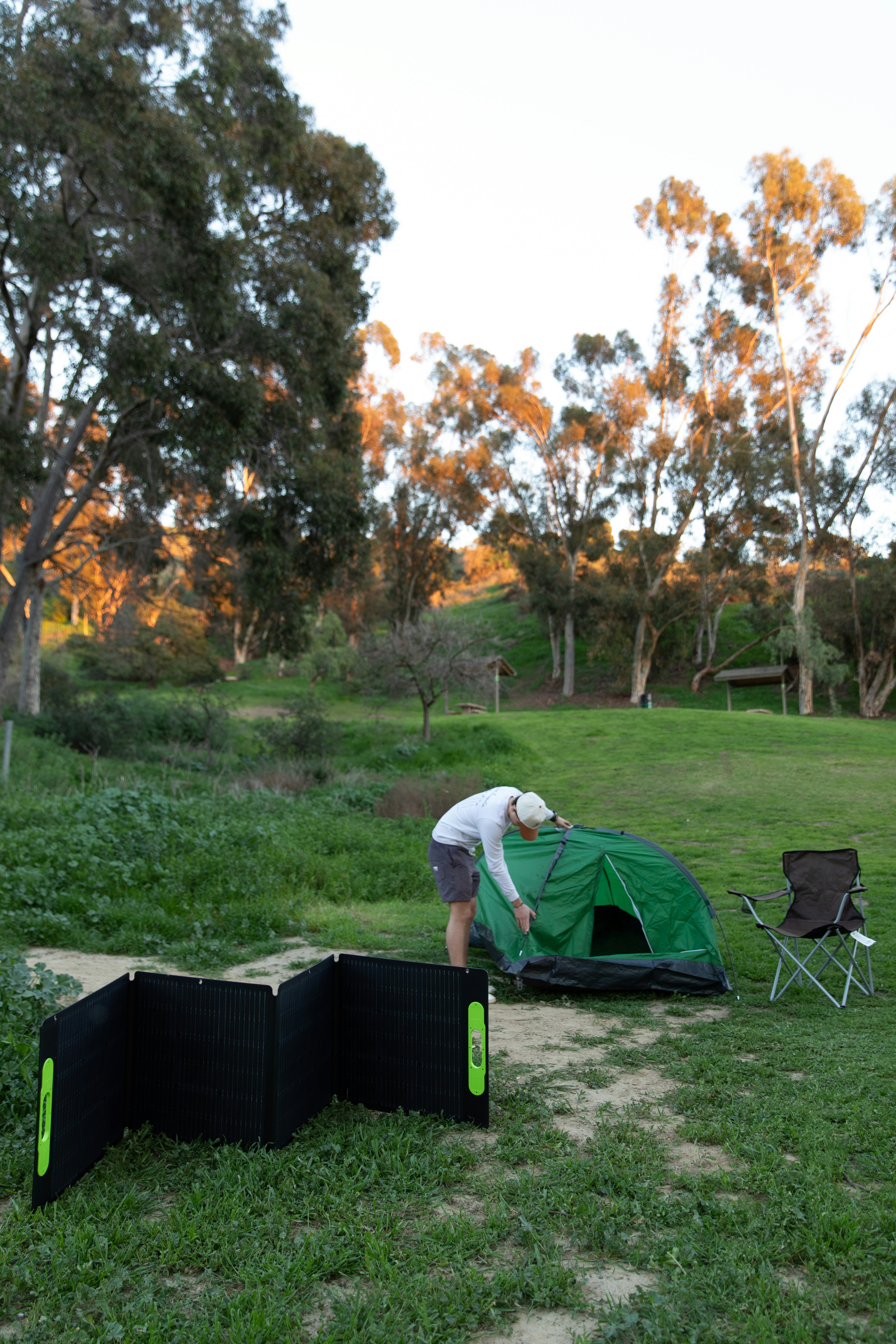 a man setting up a tent in a field