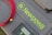 A grey textured surface features a coiled red cable, a grey device with digital display controls, and a soft case with the text 'Newpowa BE WISE GO SOLAR' in bright green lettering.