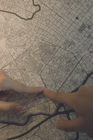 Close-up of hands pointing at a map with property boundaries and investment notes.