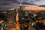 A vibrant cityscape at dusk with glowing lights.