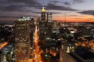 A cityscape at dusk, showcasing vibrant lights and activity.