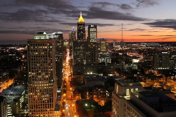 A vibrant cityscape at dusk showcasing glowing lights and bustling streets.
